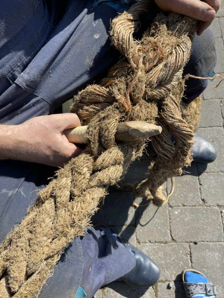 Mann spleißt Auge in dickes Schiffstau