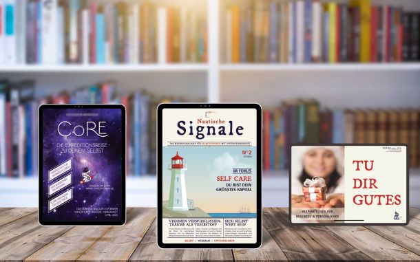 Im Hintergrund eine Regalwand mit B&uuml;chern wie in einer Buchhandlung. Auf dem Tisch davor die drei Magazinarten von Travel your Life als Cover auf einem Tablet: Links CoRE, mittig Nautische Signale, rechts Tu dir Gutes.